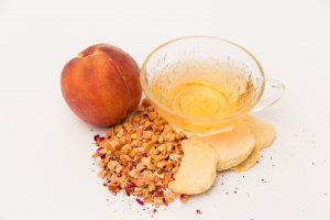 peach bellini tea with peaches and dried bits of peaches around it