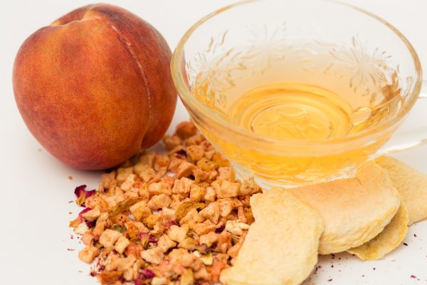 peach bellini tea with peaches and dried bits of peaches around it