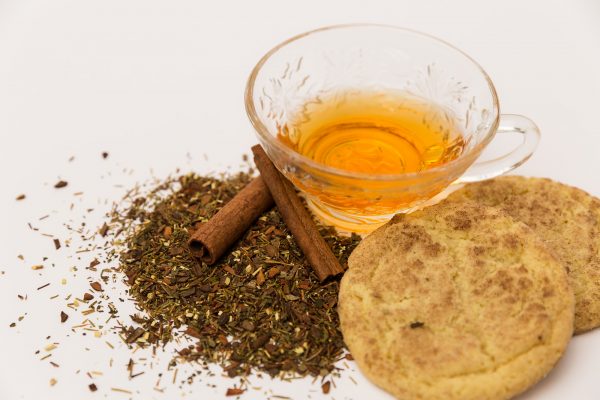 snickerdoodle tea with cookies and cinnamon sticks around it